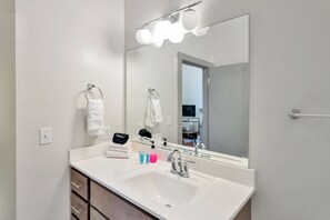 A modern bathroom with a large mirror, white sink, and a vanity with drawers. - Spacious Studio - Nearby Parking - Walk Downtown - 3F (Louisville)