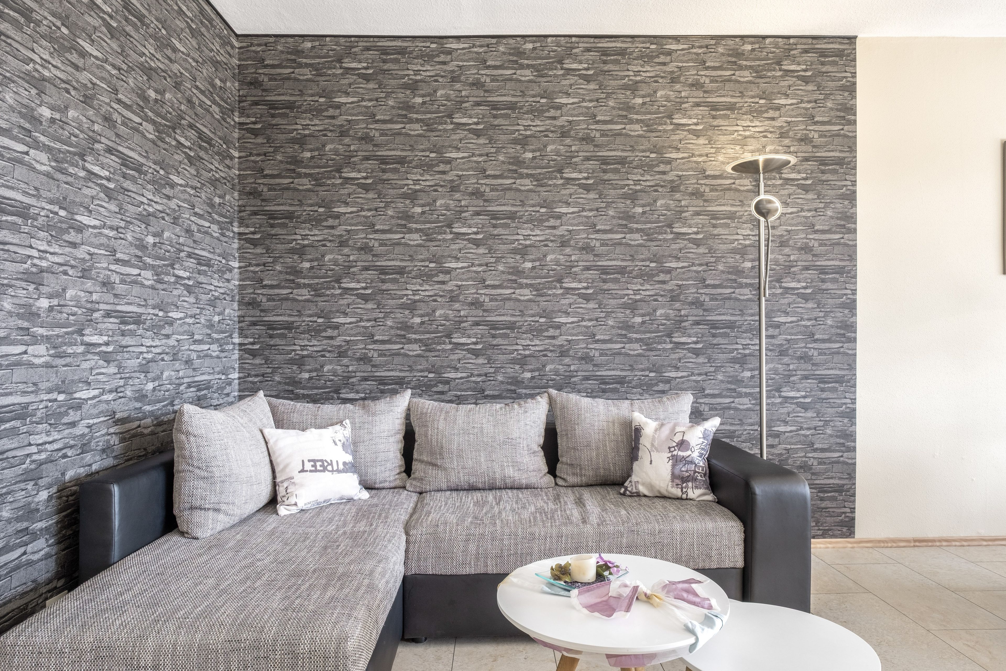A modern living room with a sectional sofa, a round coffee table, and a floor lamp.