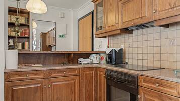 Eine Küche mit Holzschränken, einem Geschirrspüler, einem Herd und einer Kaffeemaschine.