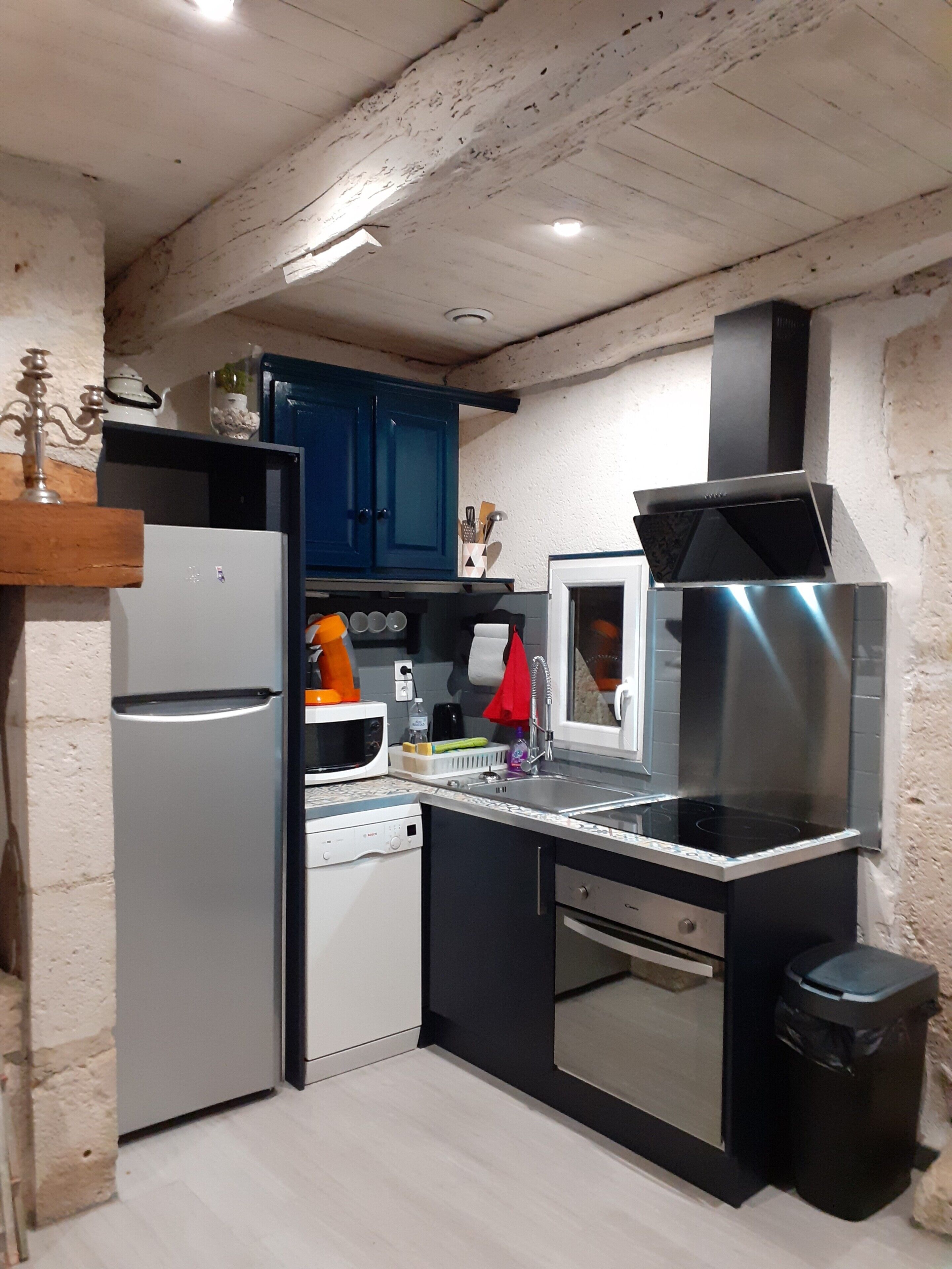A compact kitchen with a built-in dishwasher, a microwave, a stove, and a sink.
