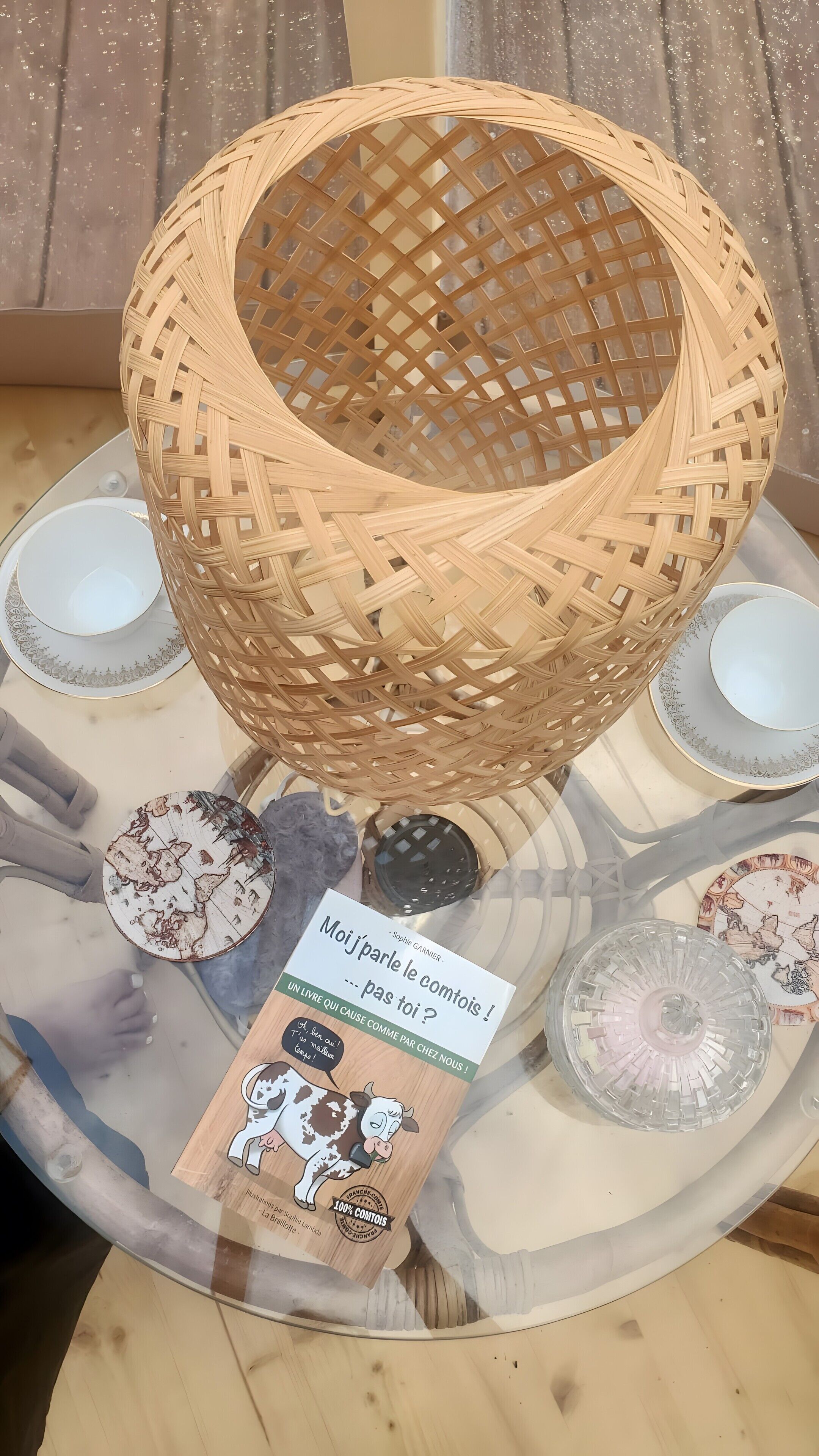 A wicker basket on a table with plates and a book.