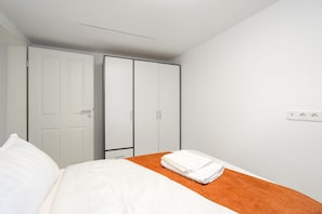 Une chambre d’hôtel avec un lit, une armoire et une prise électrique au mur.