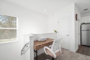 A compact kitchen with white cabinetry, a wooden countertop, and a built-in refrigerator. - New Build: B: 1BR/1BA Modern Condo in Houston (Houston)