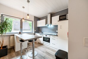 Eine moderne Küche mit Essbereich, Backofen und Mikrowelle.