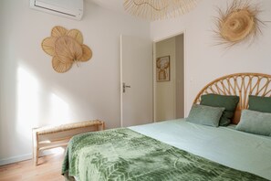Un dormitorio con cama, una banca, una puerta y adornos en la pared.