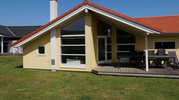 A single-story house with a red-tiled roof, large windows, and a covered patio area. - Grobenbrode Mehrgenerationen-strandrefugium (Grossenbrode)
