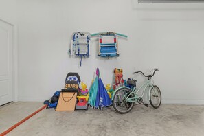 Eine Garage mit einem Fahrrad, einem Kinderwagen und verschiedenen Taschen und Spielsachen.