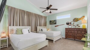 Una camera da letto con due letti, una ventola a soffitto, un comò e opere d'arte alle pareti.