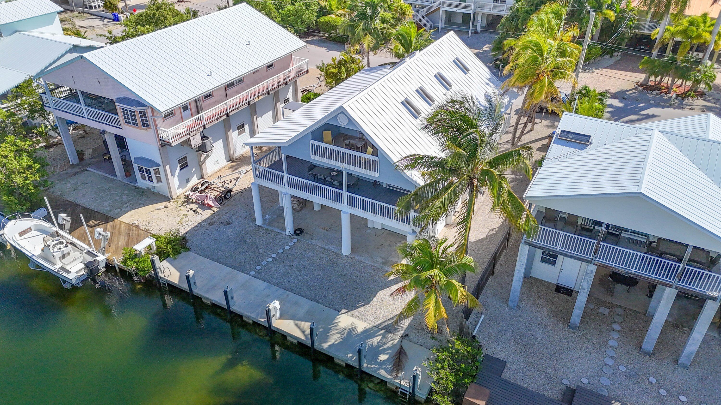 A coastal property with multiple buildings, a dock, and a boat.