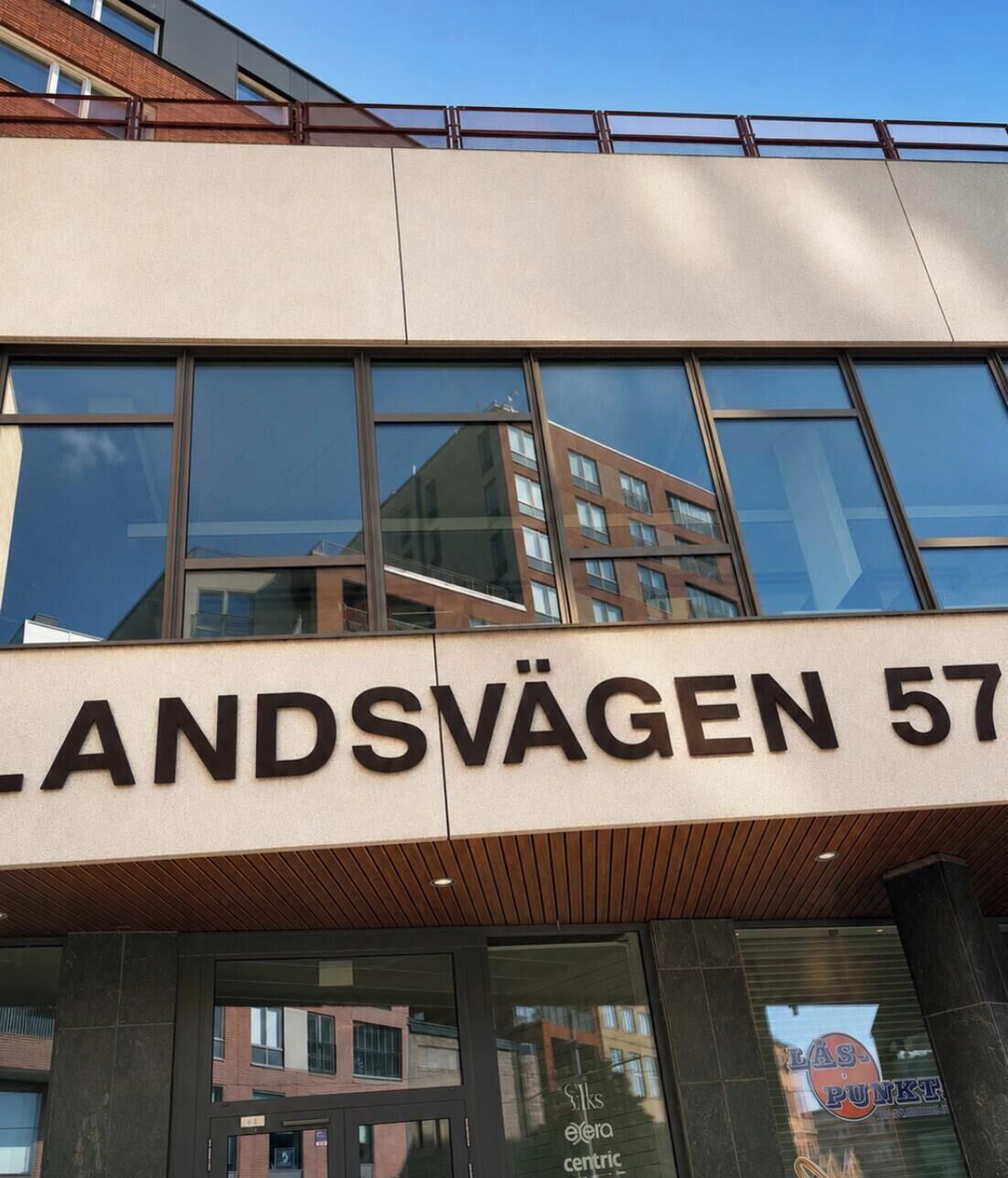 Un bâtiment portant l’enseigne « LANDSVÄGEN 57 », qui indique son adresse.