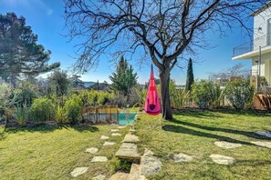 A backyard with a swimming pool, a stone pathway, and a hanging chair. - A countryside experience within walking distance of town (Aix-en-Provence)