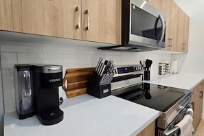 Eine moderne Küche mit Kaffeemaschine, Mikrowelle und Messerblock.