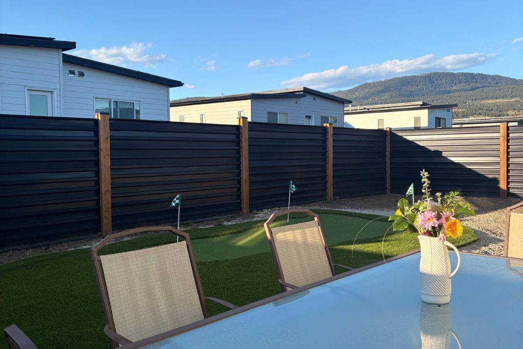 Eine Terrasse mit Tisch, Stühlen und einem Blumenstrauß.