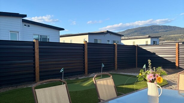 Eine Terrasse mit Tisch, Stühlen und einem Blumenstrauß.