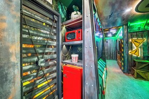A corridor with metal doors, a red microwave, popcorn containers, and a green carpet. - 8BR house sleeps 22 with spa in kissimmee (Kissimmee)
