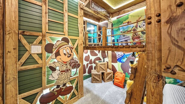 Een kamer met een houten constructie, een bord met de tekst 'Jungle Cruise' en een cartoonfiguur.
