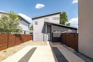 A modern two-story house with a covered driveway and a fenced backyard. - Gated 2BR | Modern Austin Home | Near DT | EV Plug (Austin)