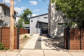 A residential property with a gated driveway, a garage, and a small front yard. - Gated 2BR | Modern Austin Home | Near DT | EV Plug (Austin)
