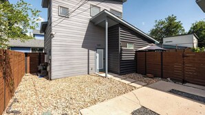 A modern two-story house with a sloped roof, a covered entryway, and a gravel driveway. - Gated 2BR | Modern Austin Home | Near DT | EV Plug (Austin)
