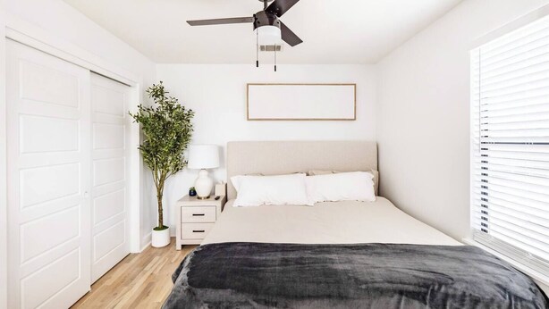 A bedroom with a bed, bedside table, lamp, and a ceiling fan. - Gated 2BR | Modern Austin Home | Near DT | EV Plug (Austin)