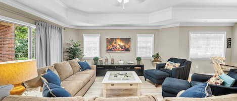 Una sala de estar con un sofá color beige, una mesa de centro y una chimenea.