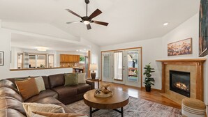 A spacious living room with a leather sofa, a round coffee table, and a fireplace.