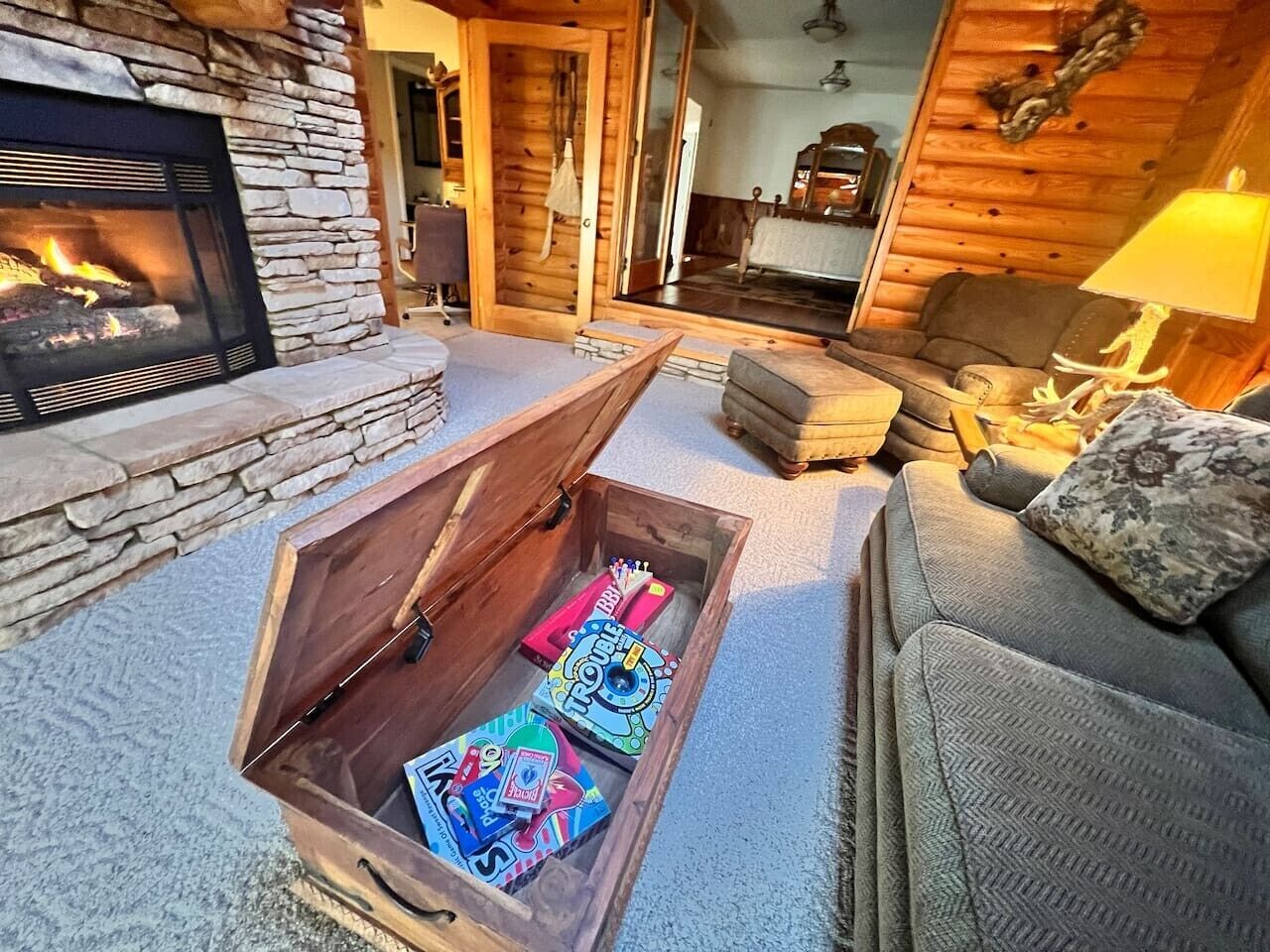 Una sala de estar acogedora con chimenea de piedra, un aparador de madera y un sofá con lámpara.