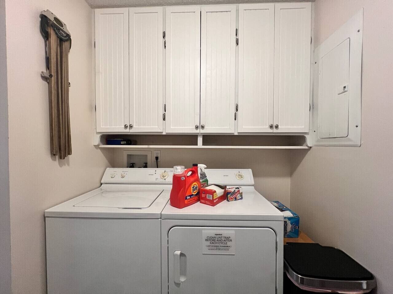 A laundry area with a washing machine, a dryer, and a cabinet with cleaning supplies.