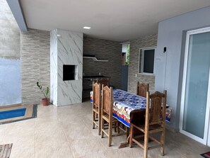 Un comedor con una mesa y sillas, una planta en maceta y vistas al exterior.