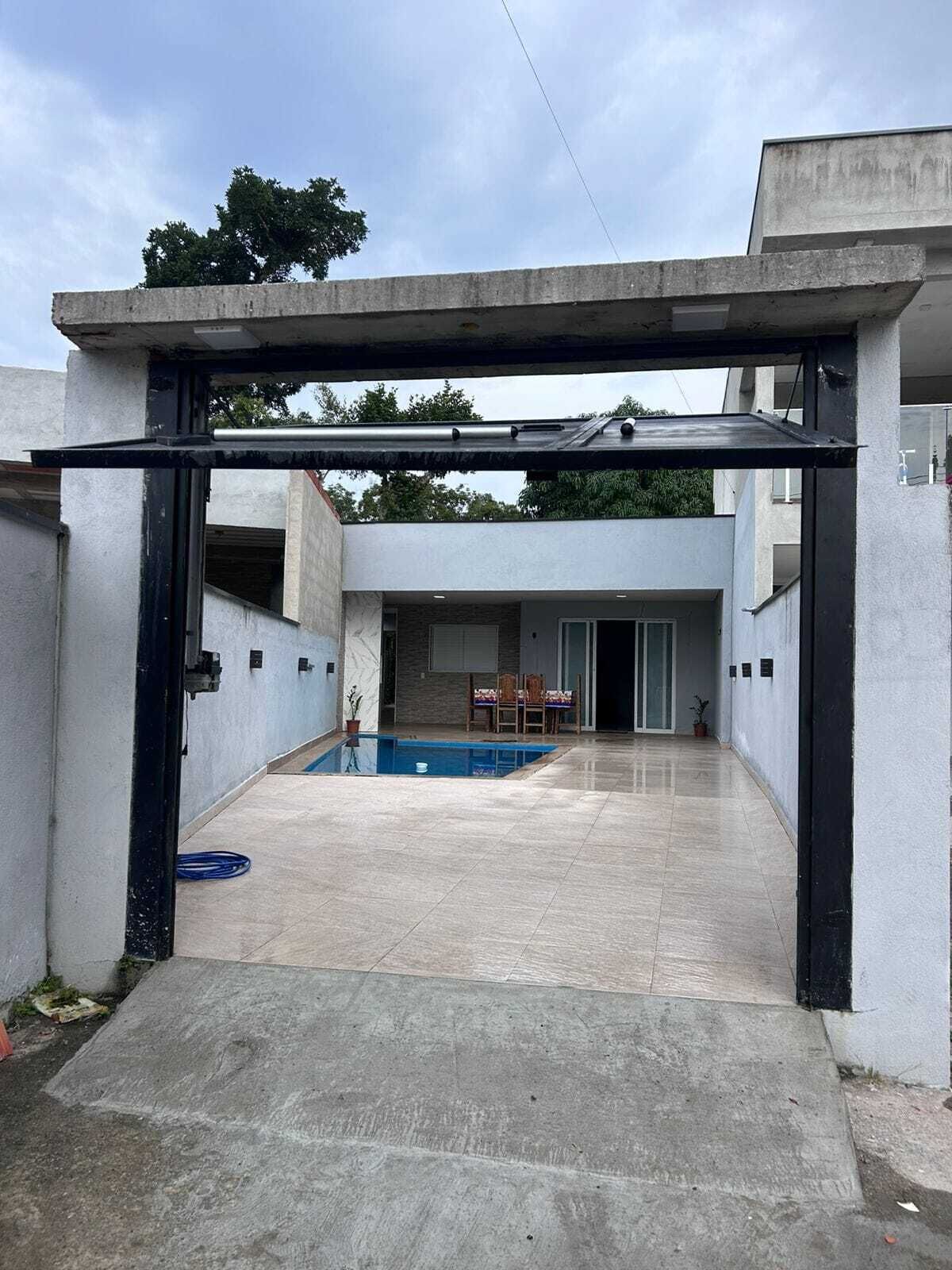 Et overdækket område med en swimmingpool, en terrasse og udsigt til en boligbygning.
