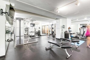 A gym with weight machines, benches, and a mirror. - Sea Colony - 603N Edgewater House (Bethany Beach)