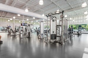 A gym with various exercise machines, a large mirror, and a TV screen. - Sea Colony - 603N Edgewater House (Bethany Beach)