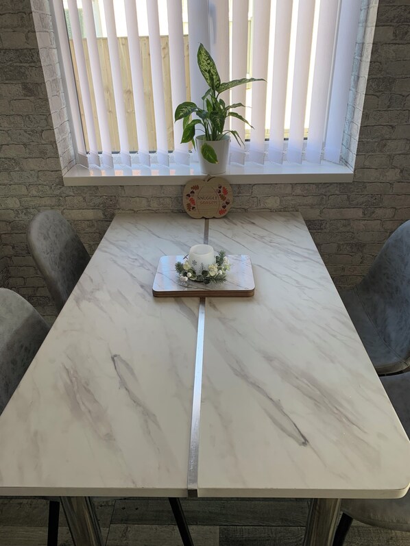 A marble table with a decorative centerpiece, a potted plant, and a wall-mounted sign.