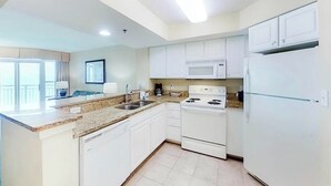 Una cocina moderna con armarios blancos, estufa, microondas y refrigerador.