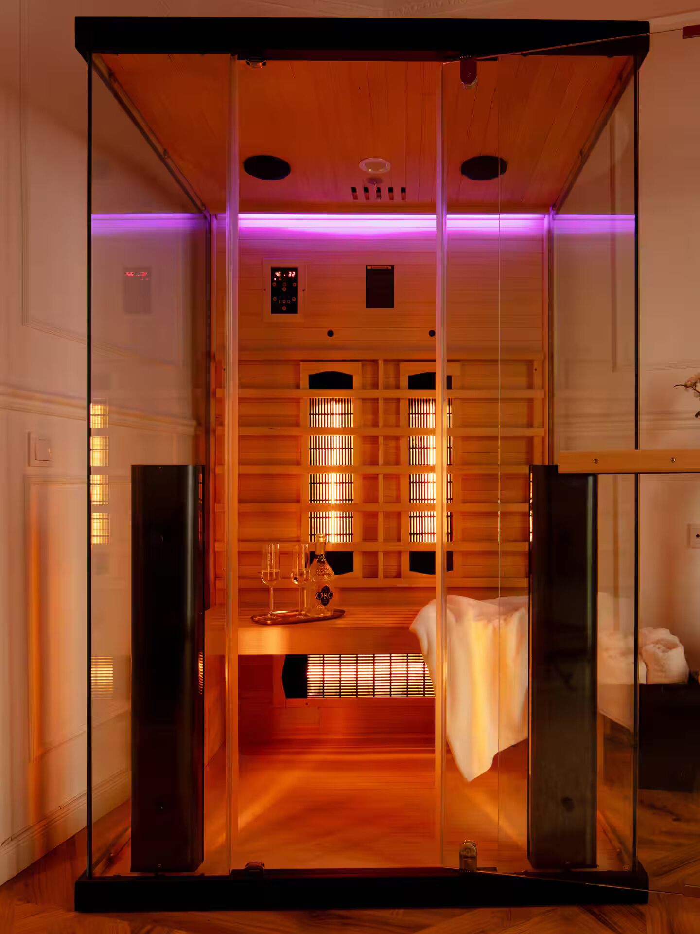 A sauna room with wooden walls, a bench, and a control panel.