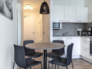 A modern kitchen with white cabinets, a microwave, and a coffee maker. - Dog-friendly Apartment in Travemunde (Lübeck)
