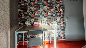 A room with a dining table, a chair, a globe, and a patterned wall.