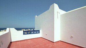 A rooftop terrace with a red-tiled floor, white walls, and a blue railing. - Luxury 4-Bedroom Villa for Rent in Amaros. (Red Sea Governorate)