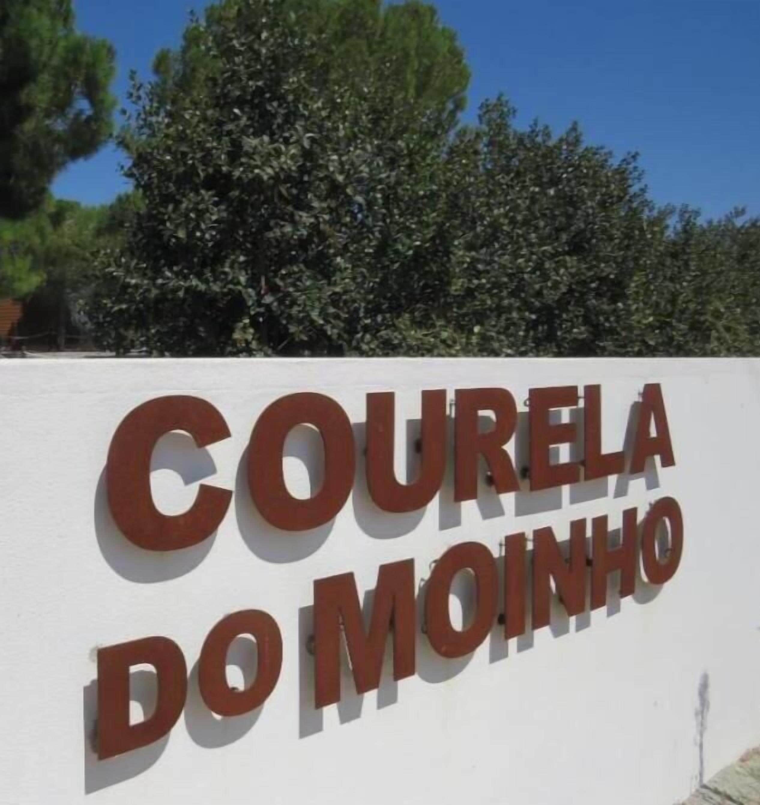 A sign with the text 'COURELA DO MOINHO' on a white wall.