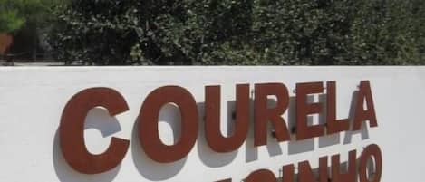 A sign with the text 'COURELA DO MOINHO' on a white wall.