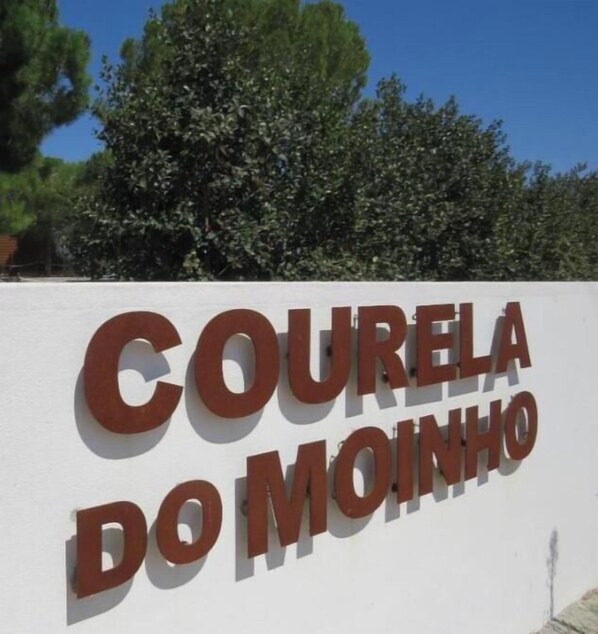 A sign with the text 'COURELA DO MOINHO' on a white wall. - A welcoming experience set among gardens, a pool, and the Alentejo countryside (Ciborro)