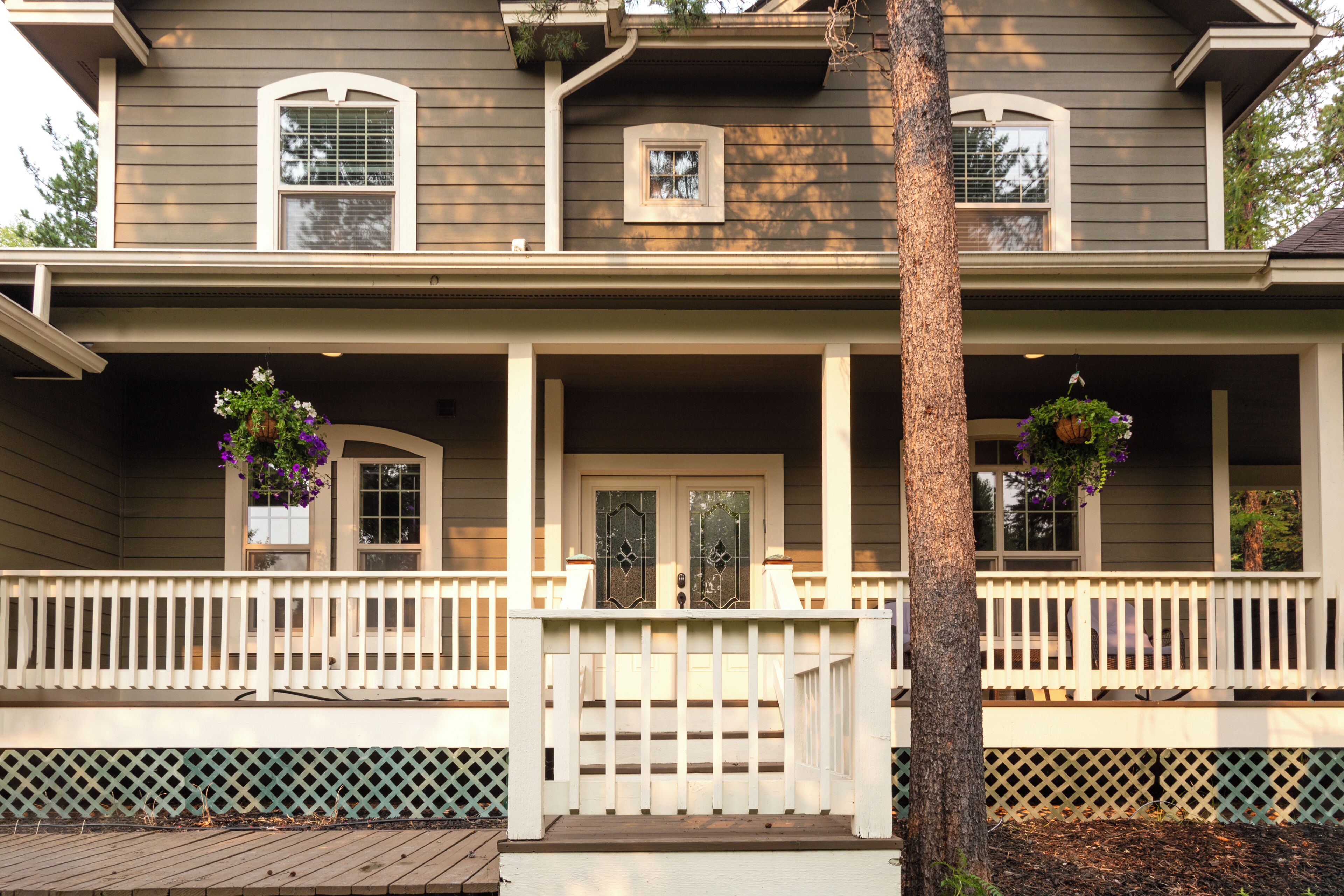 A two-story house with a porch, a front door, and a small window above the door.