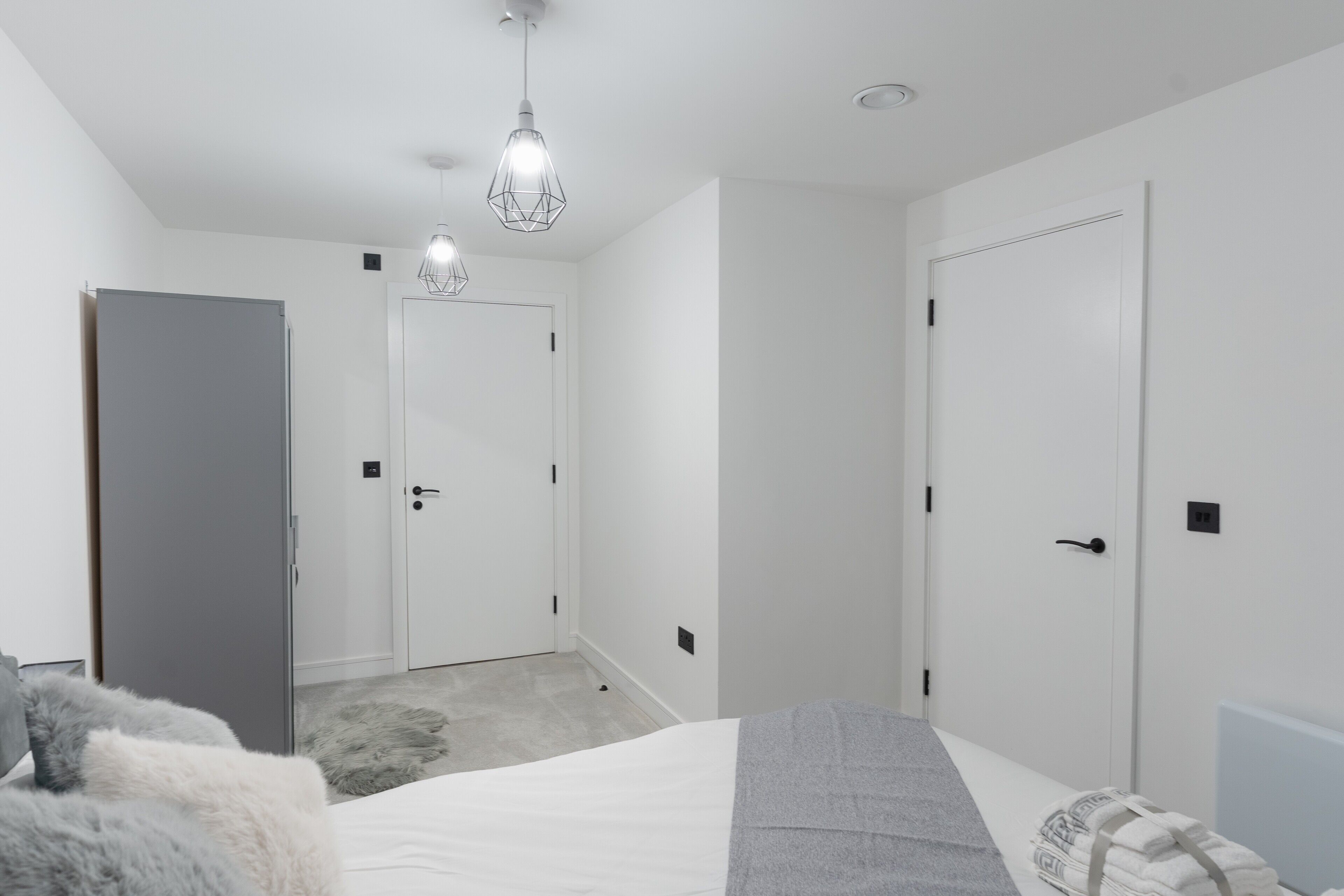 A bedroom with a bed, a wardrobe, and a door.