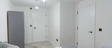 A bedroom with a bed, a wardrobe, and a door.