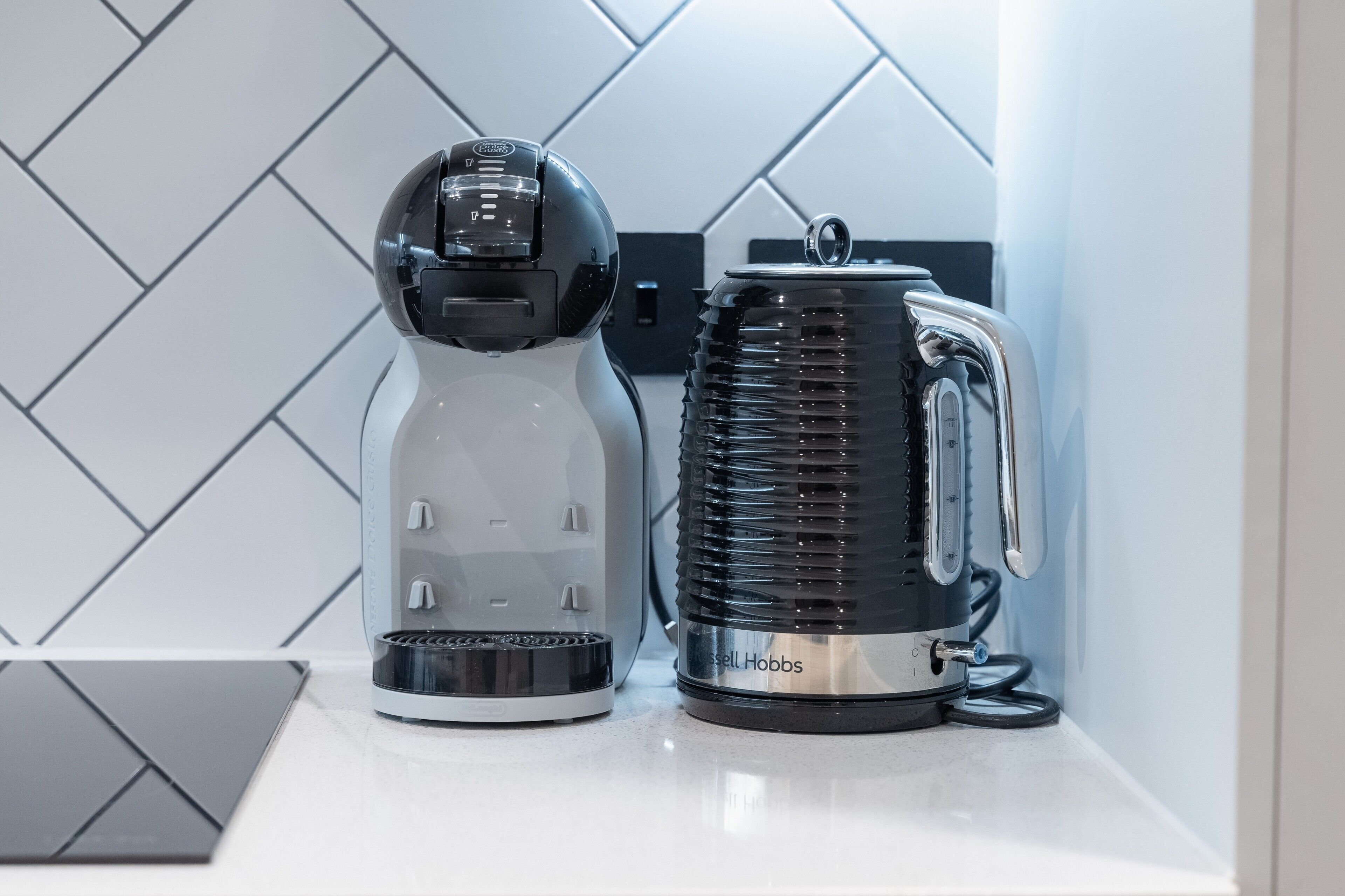 Eine Küche mit einer Kaffeemaschine und einem Wasserkocher auf einer Arbeitsplatte.