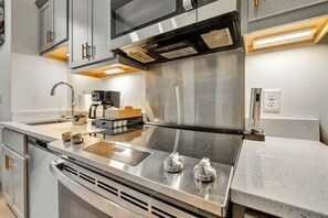 A modern kitchen with stainless steel appliances, a built-in oven, and a coffee machine. - Efficient Studio - Nearby Parking - Medical - 3F (Louisville)