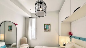 Quarto com cama, cadeira, espelho, janela com cortinas e um quadro na parede.