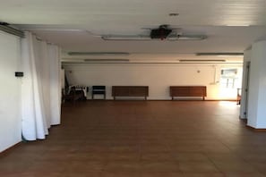 A spacious room with a high ceiling, a ceiling fan, and a large window allowing natural light. - Family Vacation Home (La Ràpita)