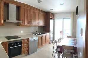 Una cocina moderna con armarios de madera, lavavajillas y horno empotrado.
