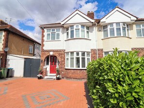 A two-story residential house with a red front door, white-framed windows, and a brick facade. - Laburnum House (Ellesmere Port)